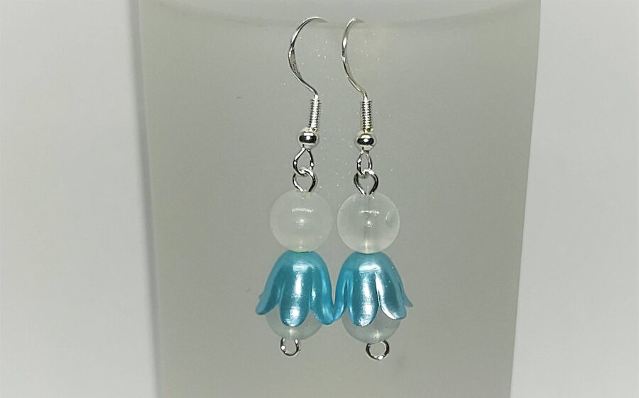 Puķu meitiņa ar zilajiem svārciņiem un krāsainām pērlītēm