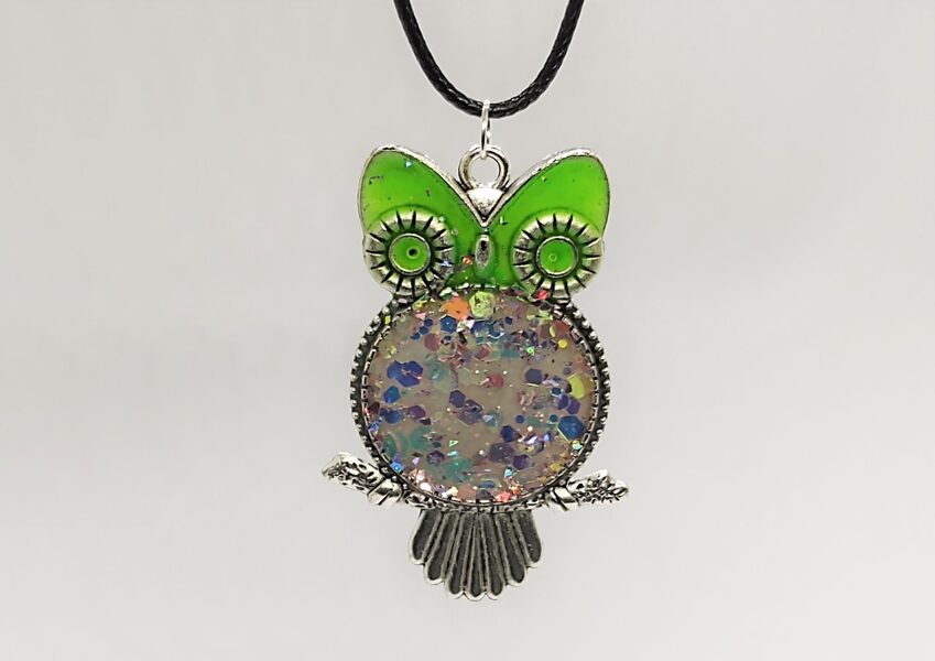 Pūce ar zaļām acīm un violetīgiem gliteriem