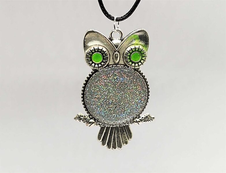 Pūce ar zaļām acīm un varavīksnes gliteriem