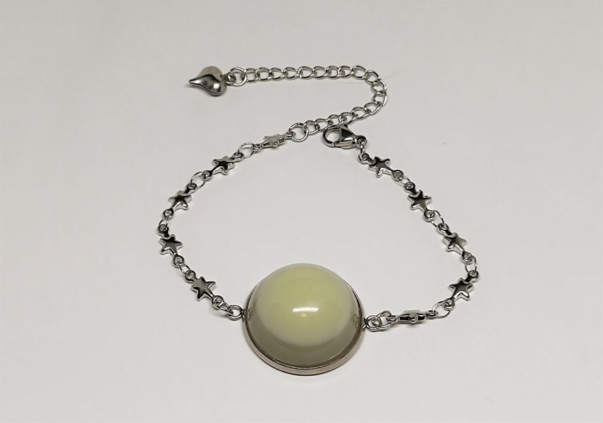 Smalka zvaigznīšu rokassprādze ar koši zaļganzilu telpisku puslodi.